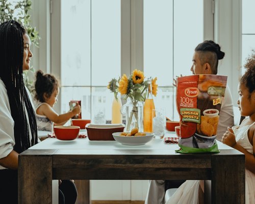Family sharing a peaceful afternoon dinner around a wooden table indoors with soft natural light